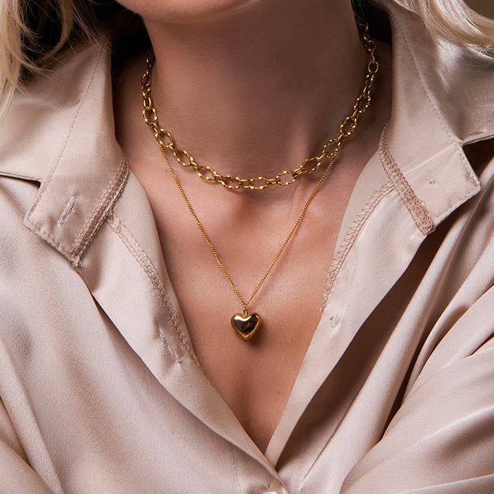 Gouden dubbele ketting met hart hanger en grove schakels – Jolan van Amberz.