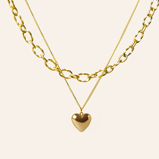 Gouden dubbele ketting met hart hanger en grove schakels – Jolan van Amberz.