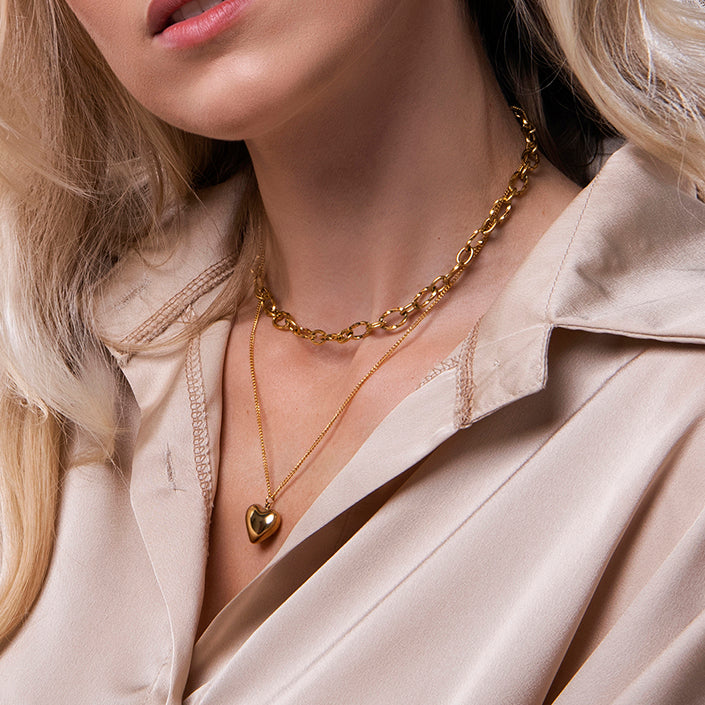 Gouden dubbele ketting met hart hanger en grove schakels – Jolan van Amberz.