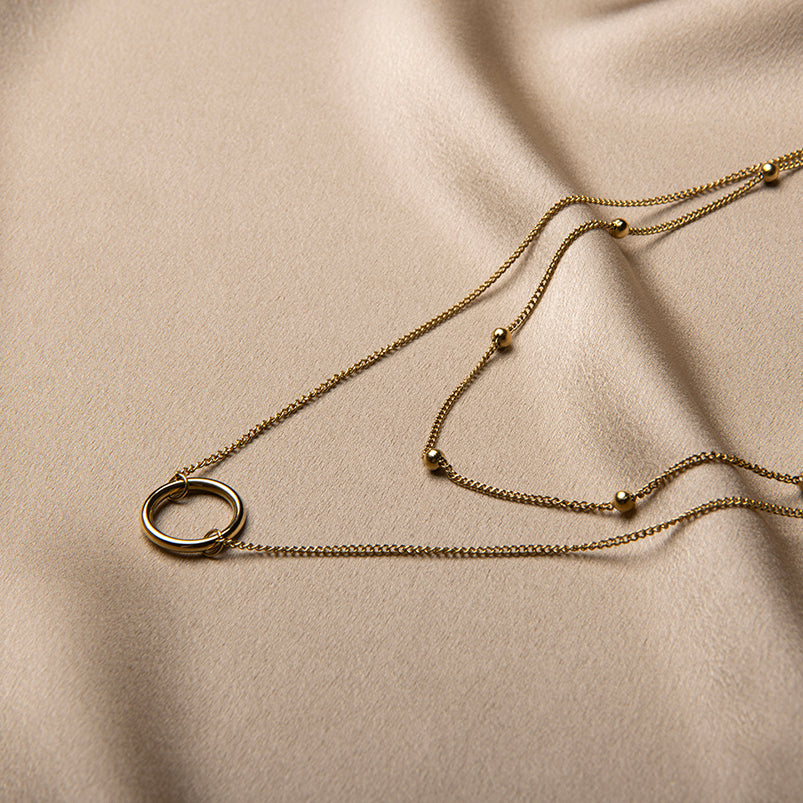 Gouden gelaagde ketting met ring hanger en bol-accenten – Livia van Amberz, waterproof en hypoallergeen.