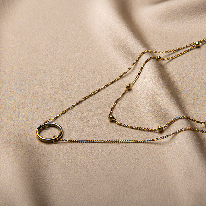 Gouden gelaagde ketting met ring hanger en bol-accenten – Livia van Amberz, waterproof en hypoallergeen.