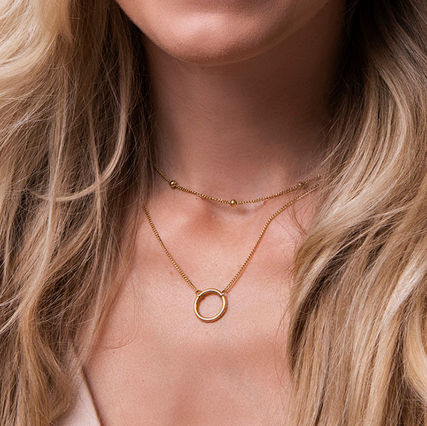 Gouden gelaagde ketting met ring hanger en bol-accenten – Livia van Amberz, waterproof en hypoallergeen.
