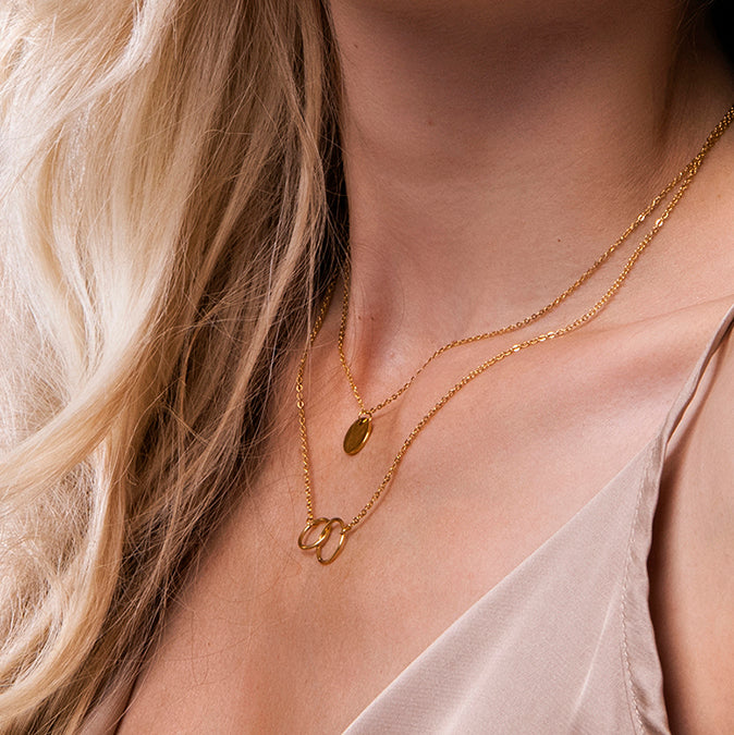 Dubbele gouden ketting dames met cirkelhanger en verbonden ringen – Mandy van Amberz