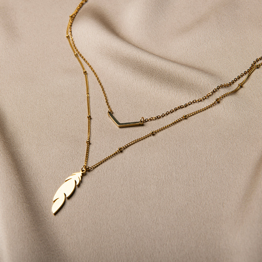 Gelaagde vergulde ketting met V-detail en veerhanger – Mari van Amberz, waterproof en hypoallergeen
