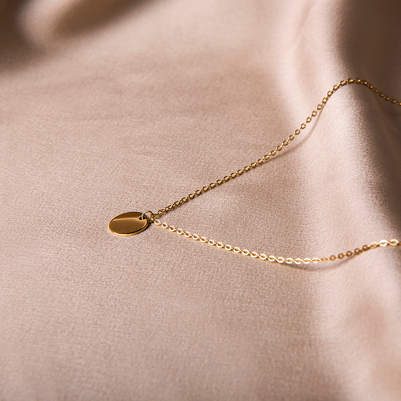 Gouden ketting met ronde munt hanger – Sandra van Amberz.