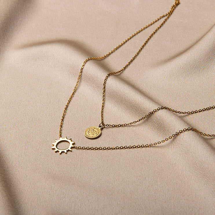 Gelaagde gouden ketting met zon hanger en muntje – Sophia van Amberz.